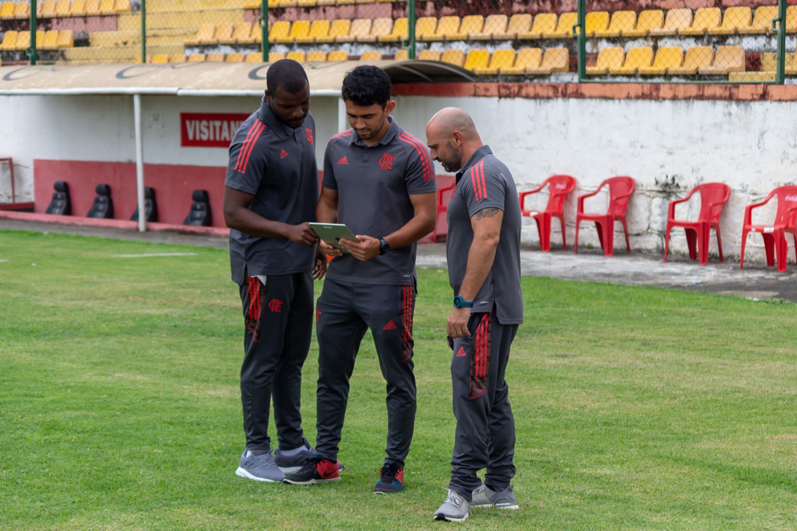 Comissão do Flamengo com tablet, à beira do campo.