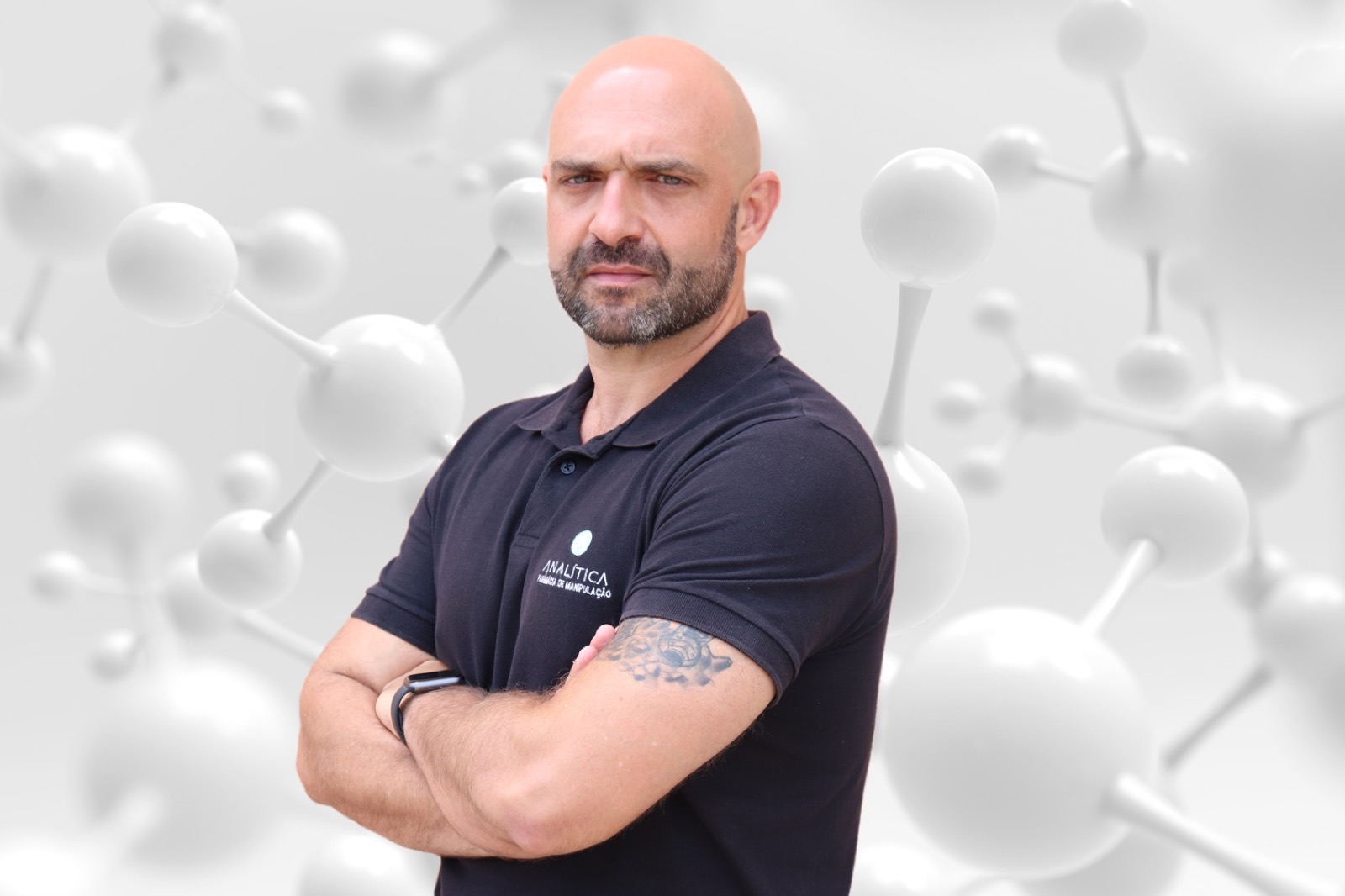Retrato de estúdio de Rodrigo Abdala com a camisa da Farmácia Analítica, diante de um fundo de moléculas.